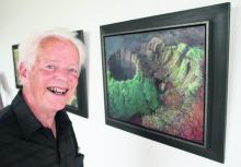 borststuk, lachend staand voor een schilderij