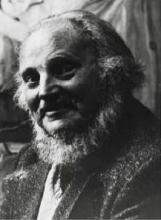 borststuk, naar links gedraaid, aankijkend, met snor en baard, in pak